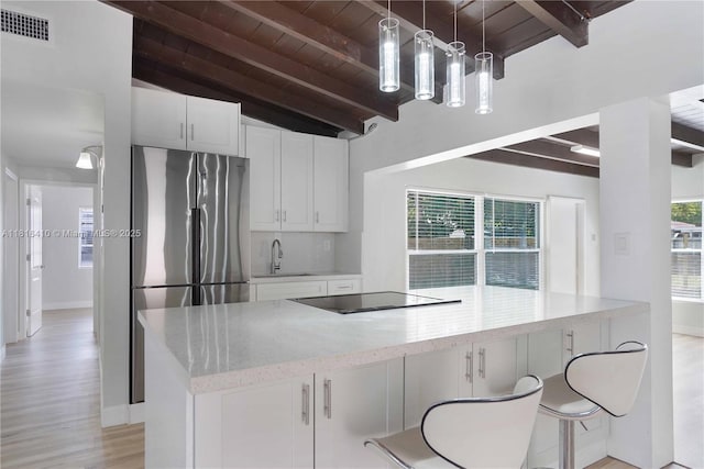 1025 SW 22nd Ter, Fort Lauderdale, FL 33312 - kitchen with wood ceiling, freestanding refrigerator, black electric stovetop, white cabinetry, and light wood-type flooring