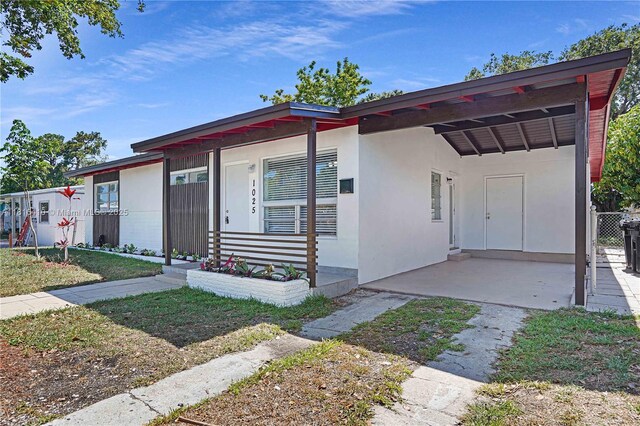 1025 SW 22nd Ter, Fort Lauderdale, FL 33312 - view of front facade featuring stucco siding and a carport