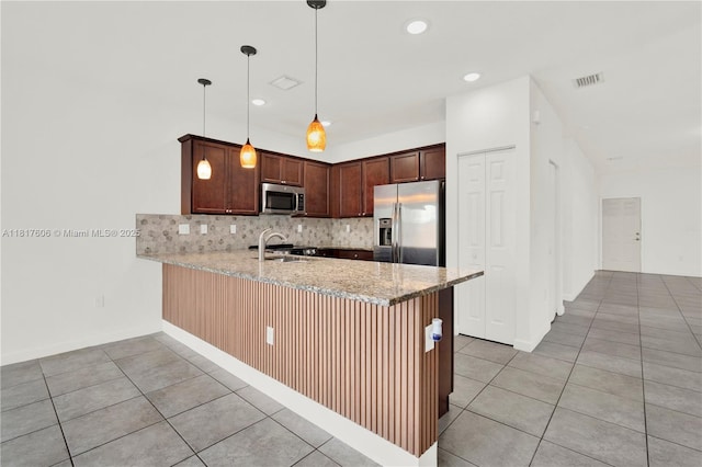 279 SE 31st Ter, Homestead, FL 33033 - kitchen featuring stainless steel appliances, light tile patterned flooring, a peninsula, tasteful backsplash, and light stone counters