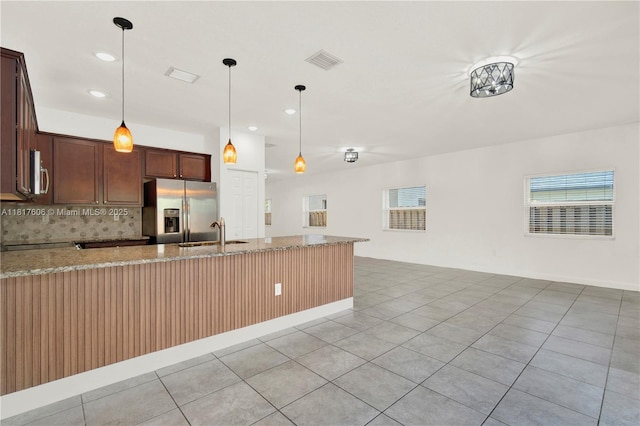 279 SE 31st Ter, Homestead, FL 33033 - kitchen with stainless steel appliances, light stone countertops, decorative backsplash, decorative light fixtures, and a peninsula