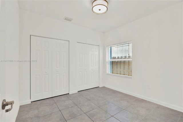 279 SE 31st Ter, Homestead, FL 33033 - unfurnished bedroom featuring multiple closets and light tile patterned flooring