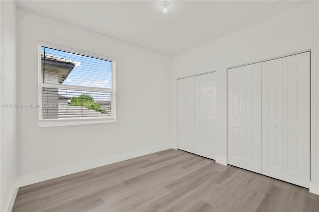 279 SE 31st Ter, Homestead, FL 33033 - unfurnished bedroom with multiple closets and wood finished floors
