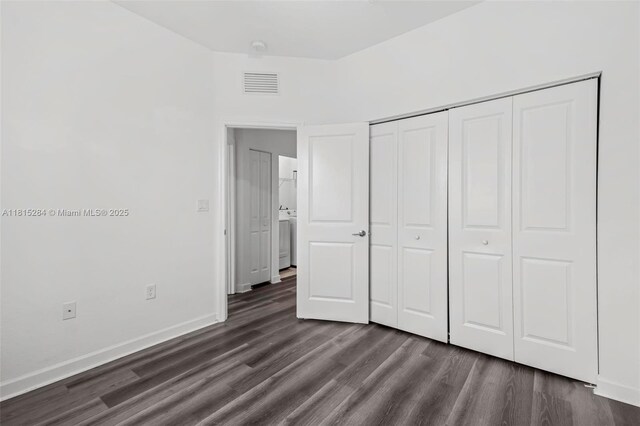2652 SE 13th St, Homestead, FL 33035 - unfurnished bedroom featuring dark wood-style floors, a closet, baseboards, and washer / dryer