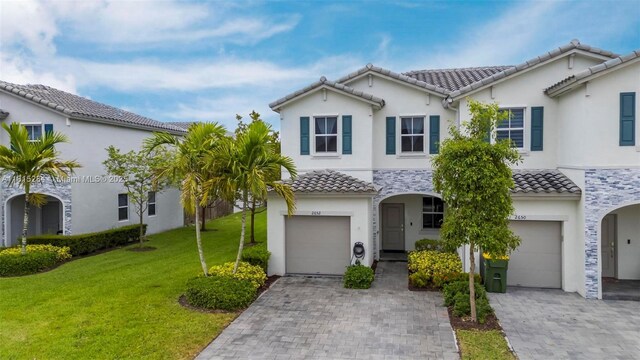 2652 SE 13th St, Homestead, FL 33035 - view of front of house featuring a garage, a tile roof, decorative driveway, a front yard, and stucco siding