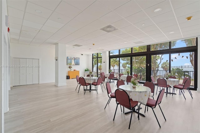 1450 Brickell Bay Dr Unit 806, Miami, FL 33131 - dining area featuring a paneled ceiling, baseboards, light wood-style flooring, expansive windows, and recessed lighting
