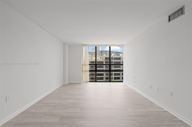 1450 Brickell Bay Dr Unit 806, Miami, FL 33131 - spare room with floor to ceiling windows, wood finished floors, and baseboards