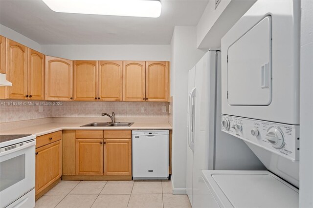 1450 Brickell Bay Dr Unit 806, Miami, FL 33131 - kitchen with white appliances, stacked washer and clothes dryer, a sink, light tile patterned floors, and light countertops