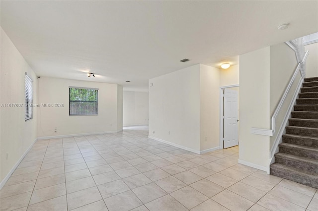 150 NE 23rd Ter, Homestead, FL 33033 - unfurnished room with light tile patterned floors, stairs, a smoke detector, and baseboards
