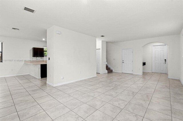 150 NE 23rd Ter, Homestead, FL 33033 - unfurnished room featuring stairs, arched walkways, light tile patterned floors, baseboards, and recessed lighting