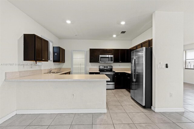 150 NE 23rd Ter, Homestead, FL 33033 - kitchen with stainless steel appliances, a sink, light countertops, a peninsula, and light tile patterned floors