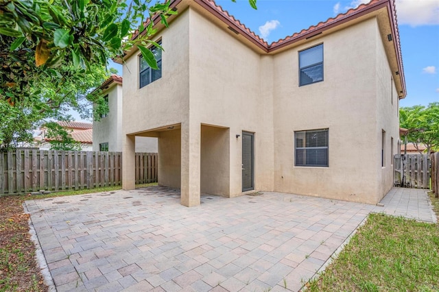 150 NE 23rd Ter, Homestead, FL 33033 - rear view of property with stucco siding, a patio area, a fenced backyard, and a tile roof