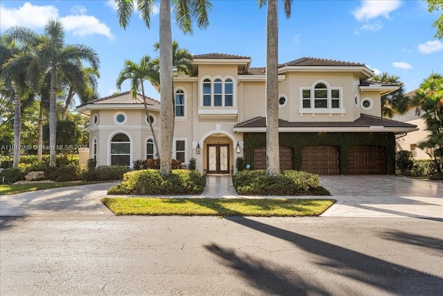 3212 NW 64th St, Boca Raton, FL 33496 - mediterranean / spanish house featuring french doors, a garage, driveway, and stucco siding