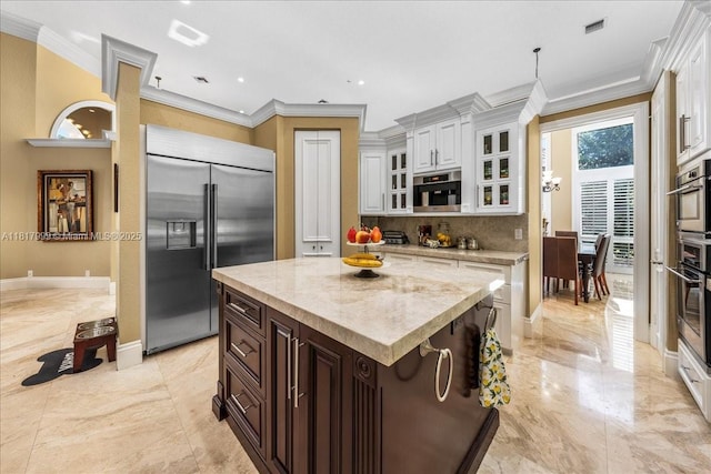 3212 NW 64th St, Boca Raton, FL 33496 - kitchen featuring stainless steel built in refrigerator, crown molding, white cabinetry, light marble finish flooring, and glass insert cabinets