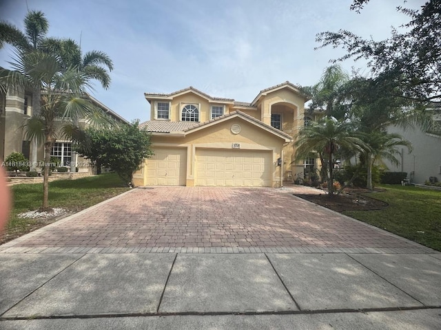 15341 SW 20th St, Miramar, FL 33027 - mediterranean / spanish house featuring decorative driveway, stucco siding, a front lawn, and a tiled roof
