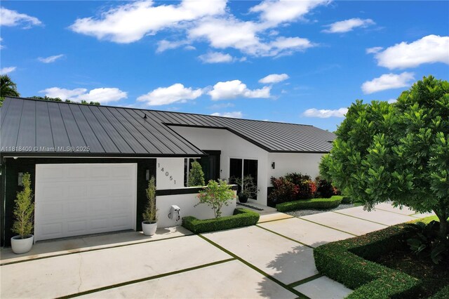 14051 SW 48th St, Miami, FL 33175 - view of front of house with a standing seam roof, metal roof, stucco siding, and an attached garage