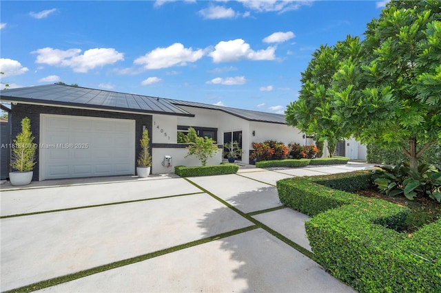 14051 SW 48th St, Miami, FL 33175 - ranch-style home with a standing seam roof, driveway, an attached garage, metal roof, and stucco siding
