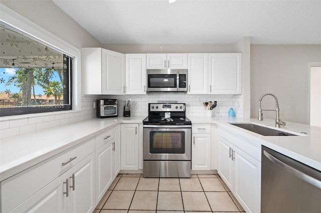 9916 SW 218th Ter, Cutler Bay, FL 33190 - kitchen featuring appliances with stainless steel finishes, a sink, backsplash, and white cabinetry