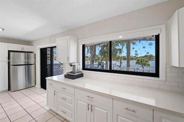 9916 SW 218th Ter, Cutler Bay, FL 33190 - kitchen with freestanding refrigerator, decorative backsplash, light tile patterned floors, and white cabinetry