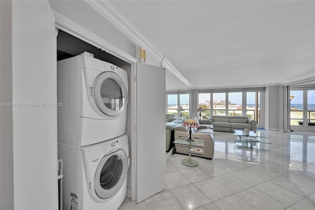 2100 S Ocean Ln Unit 703, Fort Lauderdale, FL 33316 - laundry room featuring stacked washer / dryer, crown molding, and light tile patterned floors