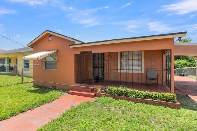 1478 NW 74th St, Miami, FL 33147 - view of front of property featuring a porch, stucco siding, and an attached carport