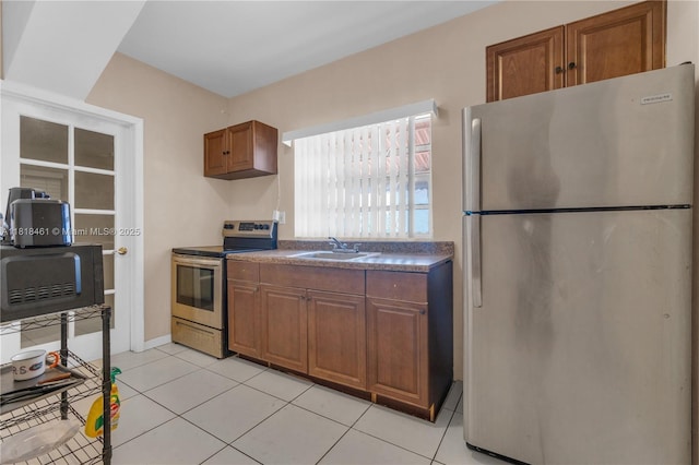 1478 NW 74th St, Miami, FL 33147 - kitchen featuring stainless steel appliances, brown cabinetry, dark countertops, and light tile patterned floors
