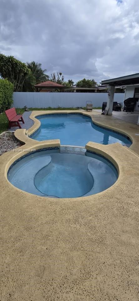7115 SW 147th Ct, Miami, FL 33193 - view of swimming pool featuring a pool with connected hot tub and a patio