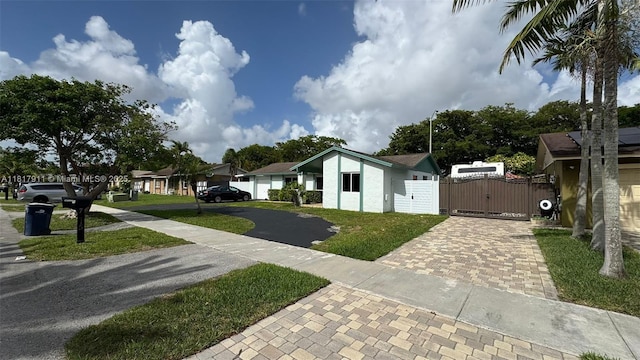 7115 SW 147th Ct, Miami, FL 33193 - view of yard featuring decorative driveway, a gate, and a residential view