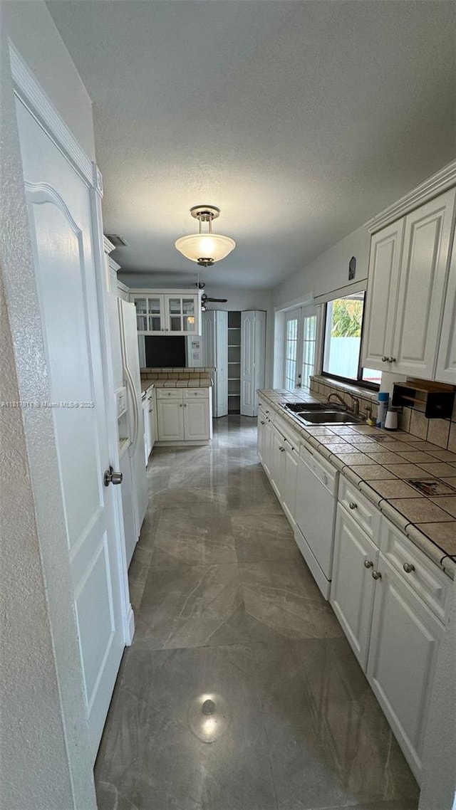 7115 SW 147th Ct, Miami, FL 33193 - kitchen with white appliances, a peninsula, white cabinetry, glass insert cabinets, and tile counters