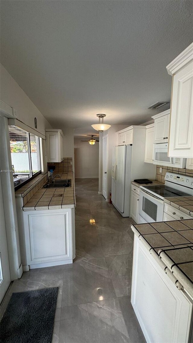 7115 SW 147th Ct, Miami, FL 33193 - kitchen with white appliances, marble finish flooring, white cabinetry, a ceiling fan, and decorative backsplash