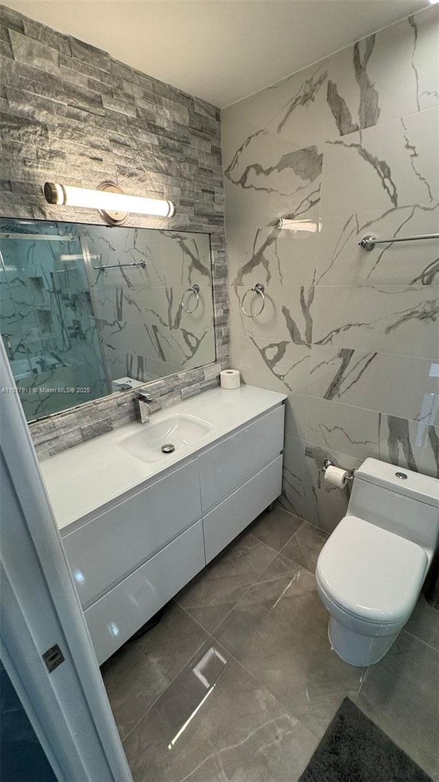 7115 SW 147th Ct, Miami, FL 33193 - bathroom with marble look tiles, vanity, a marble finish shower, tile walls, and stone wall