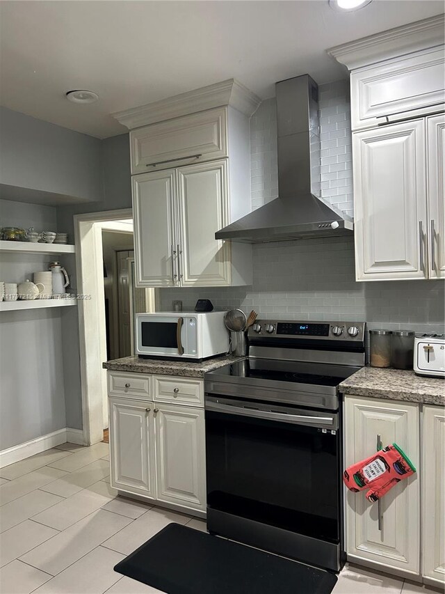 2320 SW 16th Ter, Miami, FL 33145 - kitchen with stainless steel range with electric cooktop, wall chimney exhaust hood, white microwave, tasteful backsplash, and white cabinetry
