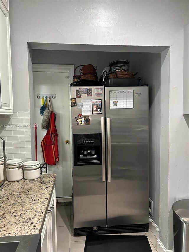 2320 SW 16th Ter, Miami, FL 33145 - kitchen featuring stainless steel fridge, white cabinets, light tile patterned floors, decorative backsplash, and light stone counters