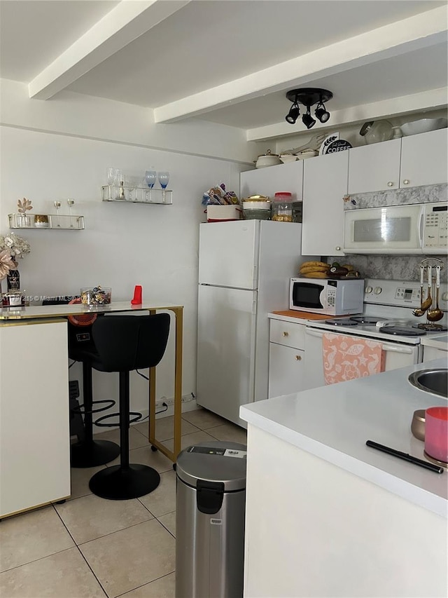 2320 SW 16th Ter, Miami, FL 33145 - kitchen featuring white appliances, light tile patterned floors, white cabinets, beam ceiling, and light countertops