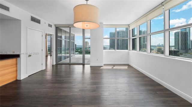 3301 NE 1st Ave Unit H1612, Miami, FL 33137 - empty room with healthy amount of natural light, a view of city, dark wood-style flooring, and baseboards