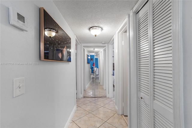 8415 SW 107th Ave Unit 323W, Miami, FL 33173 - corridor featuring a textured ceiling, light tile patterned floors, and baseboards