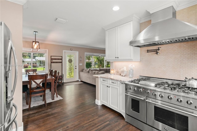 4240 SW 9th St, Plantation, FL 33317 - kitchen with stainless steel appliances, wall chimney range hood, dark wood-style flooring, tasteful backsplash, and light stone countertops