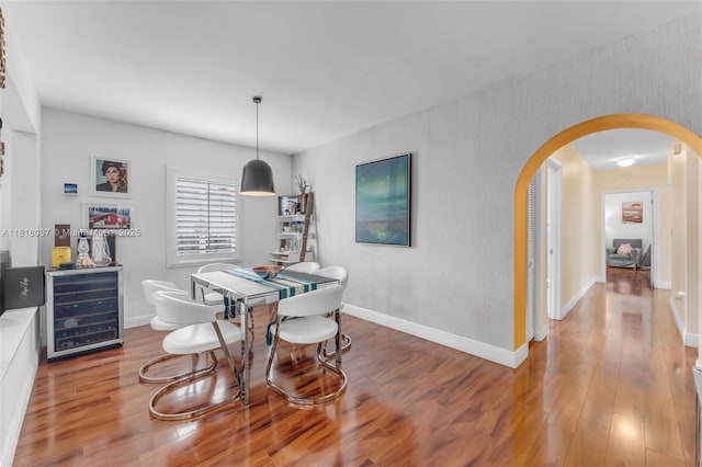 3075 SW 19th St, Miami, FL 33145 - dining room featuring beverage cooler, arched walkways, and wood finished floors