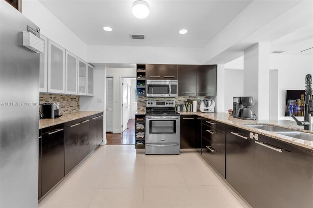3075 SW 19th St, Miami, FL 33145 - kitchen with appliances with stainless steel finishes, backsplash, light stone countertops, glass insert cabinets, and recessed lighting
