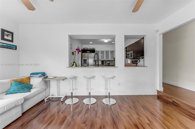 3075 SW 19th St, Miami, FL 33145 - kitchen with ceiling fan, appliances with stainless steel finishes, wood finished floors, a breakfast bar, and a peninsula