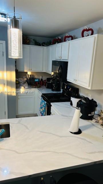 1908 NE 2nd Pl, Cape Coral, FL 33909 - kitchen featuring electric range oven, white cabinetry, and light stone counters