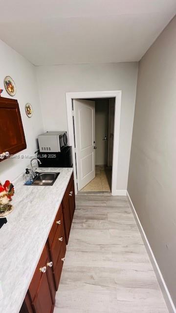 1908 NE 2nd Pl, Cape Coral, FL 33909 - kitchen with a sink and light wood-style flooring