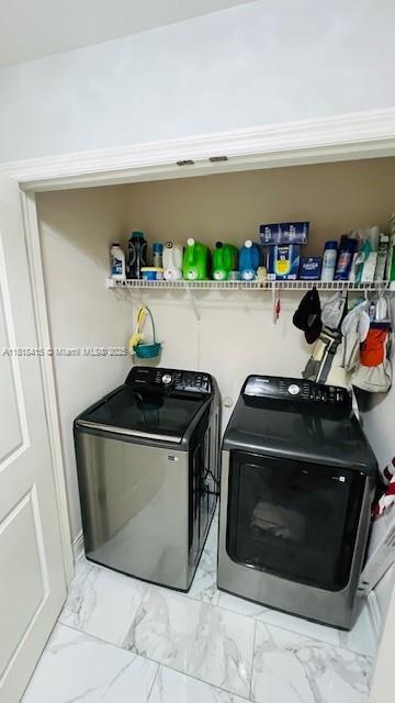1908 NE 2nd Pl, Cape Coral, FL 33909 - laundry room with washing machine and clothes dryer and light marble finish floors