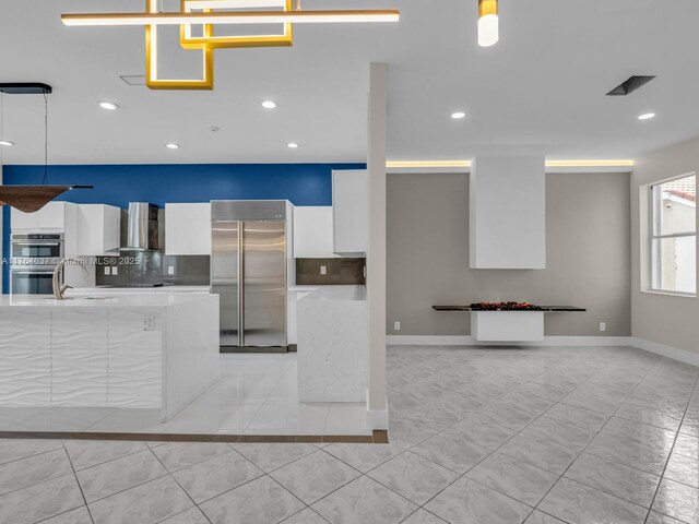 624 Stanton Dr, Weston, FL 33326 - kitchen featuring appliances with stainless steel finishes, modern cabinets, wall chimney range hood, white cabinetry, and tasteful backsplash