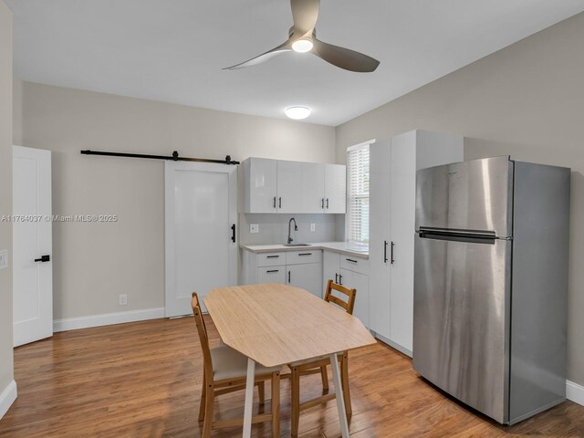 624 Stanton Dr, Weston, FL 33326 - kitchen with freestanding refrigerator, ceiling fan, light countertops, light wood-type flooring, and white cabinetry