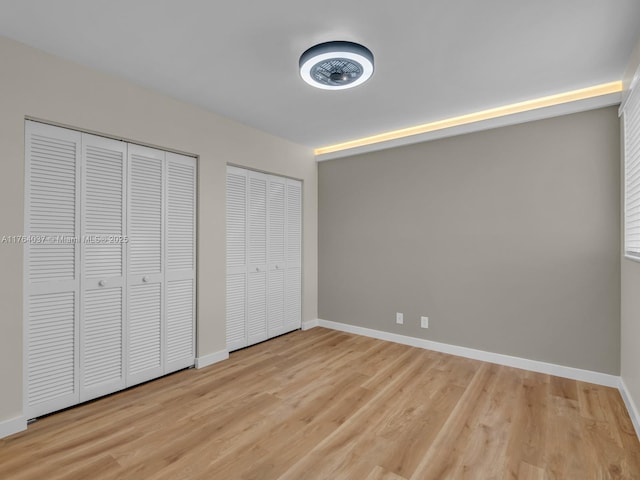 624 Stanton Dr, Weston, FL 33326 - unfurnished bedroom featuring two closets and light wood finished floors