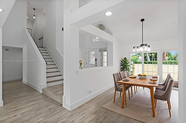 477 Spinnaker, Weston, FL 33326 - dining room featuring high vaulted ceiling, stairway, wood finished floors, baseboards, and a chandelier