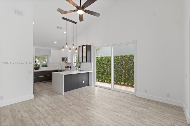 477 Spinnaker, Weston, FL 33326 - kitchen featuring stainless steel appliances, light countertops, a ceiling fan, light wood-style flooring, and high vaulted ceiling