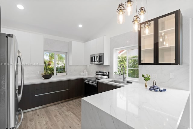 477 Spinnaker, Weston, FL 33326 - kitchen featuring appliances with stainless steel finishes, modern cabinets, light stone countertops, a sink, and white cabinetry