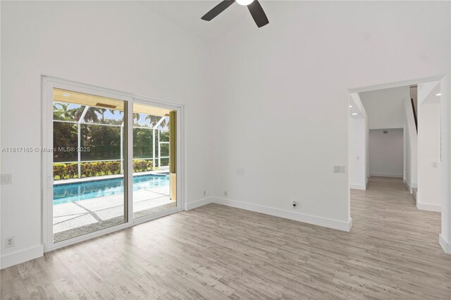 477 Spinnaker, Weston, FL 33326 - empty room with high vaulted ceiling, a ceiling fan, light wood-style flooring, and baseboards