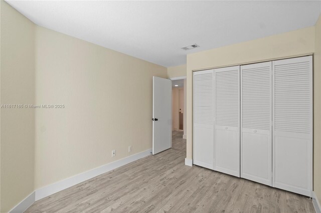 477 Spinnaker, Weston, FL 33326 - unfurnished bedroom with light wood-type flooring, baseboards, and a closet